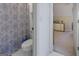 Bathroom featuring patterned shower curtain, white toilet, and neutral tile floor at 8040 Classic Dr, Jonesboro, GA 30236