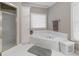 Bathroom with a soaking tub, white cabinets, and a separate shower behind a glass enclosure at 8040 Classic Dr, Jonesboro, GA 30236