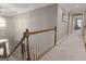 Bright, neutral hallway featuring a staircase with wood railing and carpeted floors leading to additional rooms at 8040 Classic Dr, Jonesboro, GA 30236