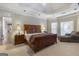 Expansive primary bedroom features a tray ceiling, sitting area, and access to an ensuite bathroom at 8040 Classic Dr, Jonesboro, GA 30236