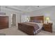 Well-lit main bedroom featuring a large bed with wooden frame and neutral-toned walls and carpet at 8040 Classic Dr, Jonesboro, GA 30236