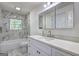 Bathroom features a modern vanity, medicine cabinet, and tiled tub with a window at 6454 Boca Grande Blvd, Forest Park, GA 30297