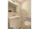 Well-lit bathroom featuring a new vanity, a sink, marble tiled wall, and toilet at 6454 Boca Grande Blvd, Forest Park, GA 30297