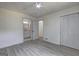 This bedroom features modern wood-look flooring, a ceiling fan, and ensuite access to the bathroom at 6454 Boca Grande Blvd, Forest Park, GA 30297