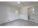 Bright bedroom showcases wood-look floors, a ceiling fan, and a glimpse into the attached bathroom at 6454 Boca Grande Blvd, Forest Park, GA 30297