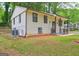 Charming two-story home featuring light yellow siding, brown trim, a covered front porch, and a well-manicured lawn at 6454 Boca Grande Blvd, Forest Park, GA 30297