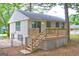 Back of house featuring a wooden deck, sliding glass doors, a well-maintained yard, and light yellow vinyl siding at 6454 Boca Grande Blvd, Forest Park, GA 30297