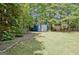 Backyard storage shed providing practical space for housing tools and equipment, set amongst mature trees and greenery at 1310 Yarborough Dr, Peachtree City, GA 30269