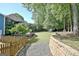Large backyard with an outbuilding, playhouse, patio furniture, retaining wall, and trees at 1310 Yarborough Dr, Peachtree City, GA 30269