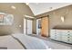 Bedroom with neutral carpet, vaulted ceiling, and barn door to ensuite at 1310 Yarborough Dr, Peachtree City, GA 30269