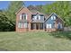 Charming two-story home with a brick and blue facade, set on a well-manicured lawn at 1310 Yarborough Dr, Peachtree City, GA 30269