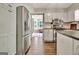 Spacious kitchen with stainless steel fridge and appliances next to a brightly lit bonus room at 1310 Yarborough Dr, Peachtree City, GA 30269