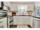 Well-appointed kitchen with stainless steel appliances, white cabinets, and tile backsplash at 1310 Yarborough Dr, Peachtree City, GA 30269