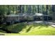 Brick home featuring a carport and lush landscaping, set against a backdrop of mature trees at 1655 Tryon Ne Rd, Brookhaven, GA 30319