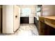 Galley kitchen with white appliances, dark cabinetry, and marble tile flooring at 1655 Tryon Ne Rd, Brookhaven, GA 30319