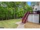 A backyard with a red staircase leading to a white deck and lush greenery at 190 Ridgecrest Dr, Fayetteville, GA 30215