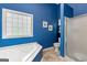 Bright blue bathroom featuring a combination tub/shower and natural light from a window at 190 Ridgecrest Dr, Fayetteville, GA 30215