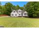 Classic home design with a well-maintained lawn, complemented by lush greenery and a bright blue sky at 190 Ridgecrest Dr, Fayetteville, GA 30215