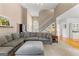 Open-concept living room with a cozy sectional sofa, staircase, and neutral color palette at 190 Ridgecrest Dr, Fayetteville, GA 30215