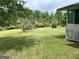 Green backyard with mature trees and a partial view of the home at 8315 Ridge Rd, Fairburn, GA 30213