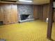 Open view of an unfinished basement with paneled walls and brick fireplace at 8315 Ridge Rd, Fairburn, GA 30213