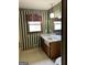 Bathroom features green and white striped wallpaper, window, and wood vanity at 8315 Ridge Rd, Fairburn, GA 30213