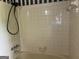 The shower boasts neutral tile, chrome fixtures, and a handheld shower head at 8315 Ridge Rd, Fairburn, GA 30213