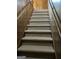 Carpeted staircase featuring wood-paneled walls and matching handrails at 8315 Ridge Rd, Fairburn, GA 30213