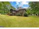 Spacious backyard with a covered porch, lush green lawn, and landscaping offering great outdoor space at 40 High St, Sharpsburg, GA 30277