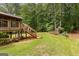 Backyard view of home featuring a wooden deck, stairs, and lush green grass at 40 High St, Sharpsburg, GA 30277