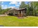 Backyard view with deck, stairs, screened in porch, and spacious grassy area at 40 High St, Sharpsburg, GA 30277