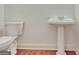 Cozy bathroom featuring wood floors, a pedestal sink, and a standard toilet at 40 High St, Sharpsburg, GA 30277