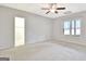 Spacious carpeted bedroom with a ceiling fan, a window view and entry to bathroom at 40 High St, Sharpsburg, GA 30277