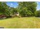 Beautifully landscaped front yard with mature trees and healthy grass, enhancing the home's curb appeal at 40 High St, Sharpsburg, GA 30277