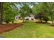 Beautiful front exterior with lush green lawn, mature trees, and charming landscaping, complementing the home's design at 40 High St, Sharpsburg, GA 30277
