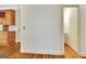 Hallway with wood floors leading to a kitchen with wood cabinets and an open doorway to a bathroom at 40 High St, Sharpsburg, GA 30277