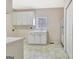 Bright kitchen featuring white cabinets, a sink beneath a window, and a white refrigerator at 40 High St, Sharpsburg, GA 30277
