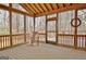 Cozy screened porch with wood ceiling and railings, and view of a wooded yard at 40 High St, Sharpsburg, GA 30277