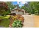 Side exterior with two-car garage and landscaped features enhance the property's curb appeal at 40 High St, Sharpsburg, GA 30277