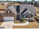 Aerial view of a brick home with a two-car garage and well manicured lawn at 3226 Puritan Way, Mcdonough, GA 30252