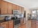 Well-lit kitchen boasts stainless steel appliances and warm wood cabinets, plus a view into a pantry at 3226 Puritan Way, Mcdonough, GA 30252