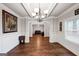 Open dining room with hardwood floors, wainscoting, chandelier, and view to living space at 412 Guildhouse Dr # 38, Mcdonough, GA 30252