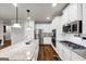 Well-lit kitchen featuring granite countertops, stainless steel appliances, and white cabinetry at 412 Guildhouse Dr # 38, Mcdonough, GA 30252