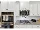 Close up of a stainless steel gas range, microwave, and white subway tile backsplash at 412 Guildhouse Dr # 38, Mcdonough, GA 30252