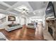 Open-concept living room with hardwood floors, stone fireplace, coffered ceilings, and staircase access at 412 Guildhouse Dr # 38, Mcdonough, GA 30252