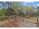 Wooden deck with railing provides outdoor living space, and a view to the trees and yard at 470 Old Griffin Rd, Hampton, GA 30228