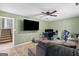 Spacious living room featuring a plush sofa, large tv, ceiling fan, and stairway at 470 Old Griffin Rd, Hampton, GA 30228