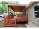 A side view of the back porch, showing the stairs and roof covering with trees in the background at 208 Holliday Way, Carrollton, GA 30116