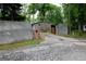 Wide driveway view of home behind a wall with a wooden gate entry and brick mailbox stand at 208 Holliday Way, Carrollton, GA 30116