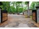 Gated view of the gravel driveway with multiple vehicles and some construction equipment at 208 Holliday Way, Carrollton, GA 30116